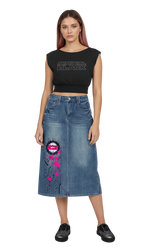 A model wearing a black sleeveless crop top with 'ARTIFICIAL BLACK' printed on the chest and a blue denim midi skirt featuring a pink and black graphic print on the lower left leg, paired with black shoes, against a plain white background.